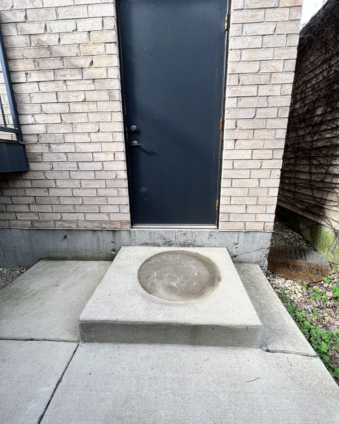 Stained concrete entry stoop before power washing